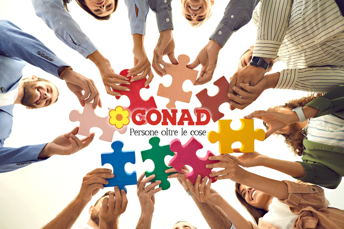 Shot from below of team of happy business people connecting pieces of jigsaw puzzle